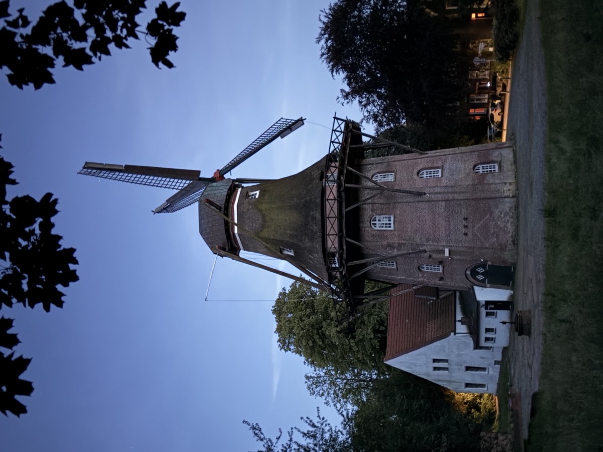 Die Mühle in der Abenddämmerung mit Müllerhaus und Brunnen