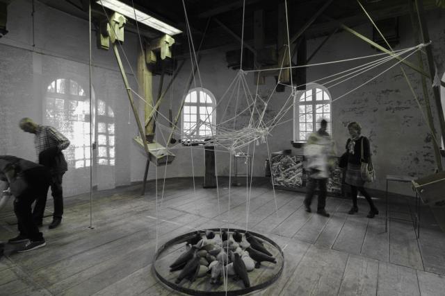 Kunstinstallation mit Fäden und Vogelfiguren im Achtkant der Mühle